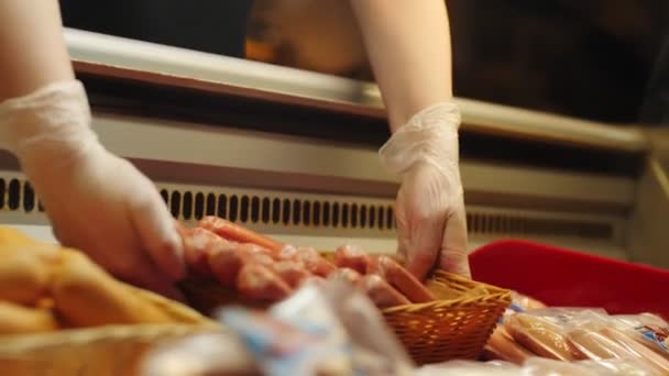 Femme met panier avec de délicieuses saucisses dans la vitrine boutique — Video