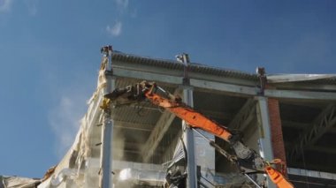 Kazı makinesi mavi gökyüzünün altındaki beton desteğini yok etti