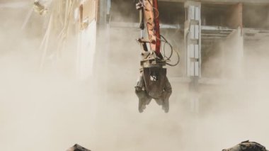 Yıkım alanında toza bulanmış büyük metal makaslı makine.