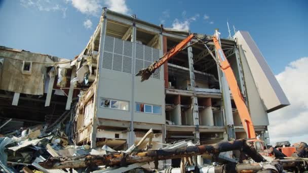Екскаватор руйнує бетонну стіну зруйнованої арени будівлі — стокове відео