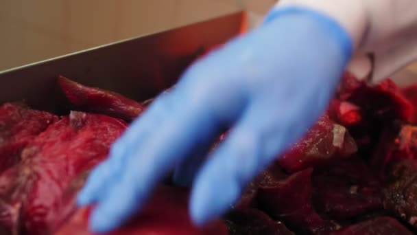 Arbeiter steckt rohes Fleisch in Hackmaschine in Werkstatt — Stockvideo