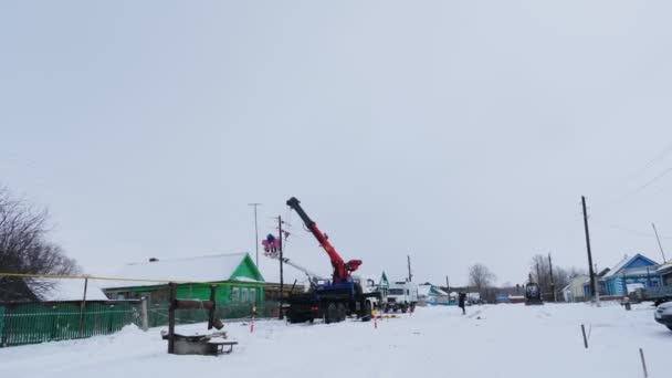 Técnicos de reparación de líneas eléctricas en la aldea en el día de invierno — Vídeos de Stock