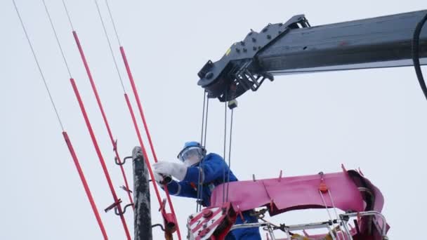 Dipendente lavora con fili su linea di trasmissione di energia rustica — Video Stock