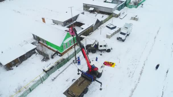 Lavoratori con gru fissano linee di trasmissione di potenza nel villaggio — Video Stock