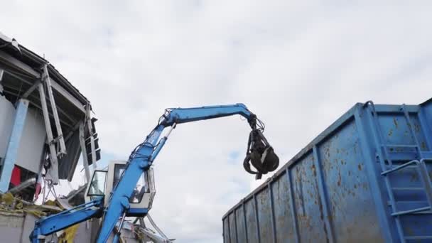 Máquina coloca lixo em enorme recipiente no local de demolição — Vídeo de Stock