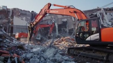 Kazıcılar, yıkılmış hokey arenasının enkazını söküyor.