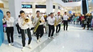 Orkestra, alışveriş merkezinde farklı enstrümanlar çalıyor.