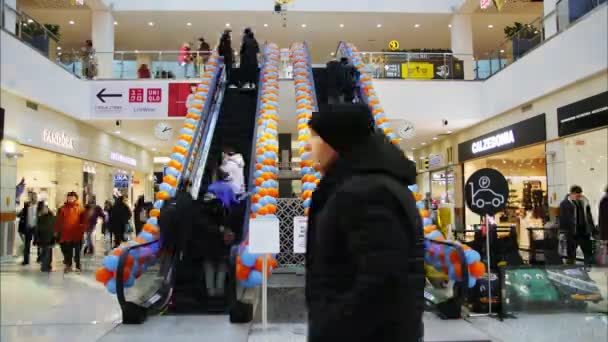 Klanten gaan op roltrap en loopt langs winkels in winkelcentrum — Stockvideo