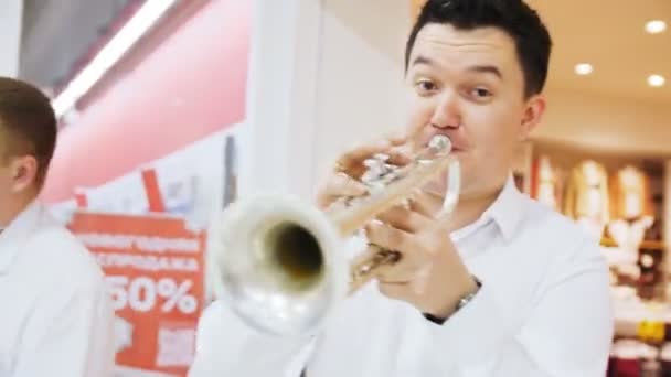 Allegro musicista suona il trombone con la band nella sala del centro commerciale — Video Stock