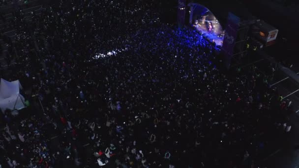 Люди смотрят выступление на сцене с фейерверком сверху — стоковое видео