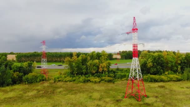 Elektrické přenosové věže na zeleném poli u silnice — Stock video