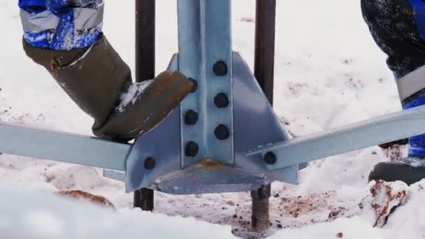 I dipendenti installano la torre della linea elettrica nel terreno congelato — Video Stock