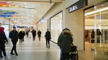 Müşteriler alışveriş merkezlerinde moda mağazalarıyla birlikte yürürler.