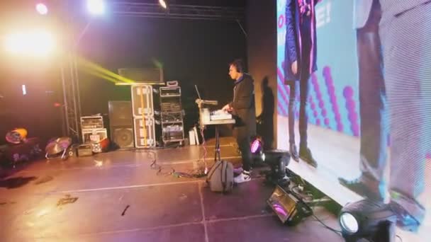 Jonge dj speelt muziek op console op het podium in de winter avond — Stockvideo
