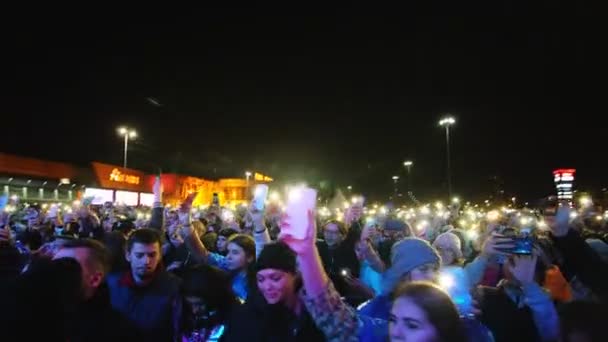 Dav s mobily sleduje hudební show v zimním večeru — Stock video