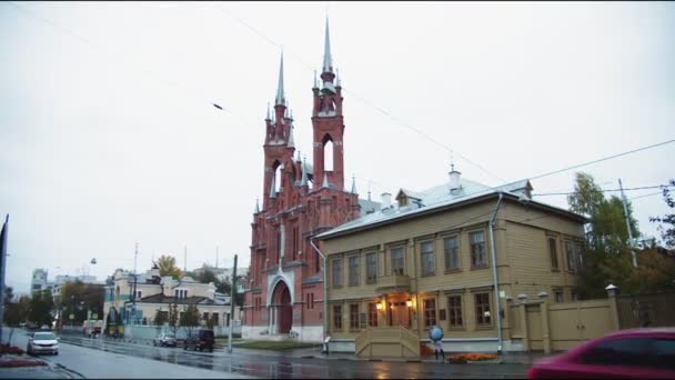 Edificio di chiesa cattolica in strada di città durante giorno piovoso — Video Stock
