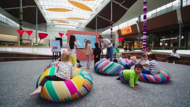 Vrijwilligers brengen tijd door met kleine kinderen in het winkelcentrum — Stockvideo