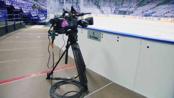 Камера на штативе готова снимать хоккейный матч на катке — стоковое видео