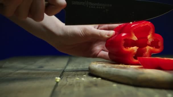 Lady darabok szelet finom érett piros harang paprika az asztalon — Stock videók
