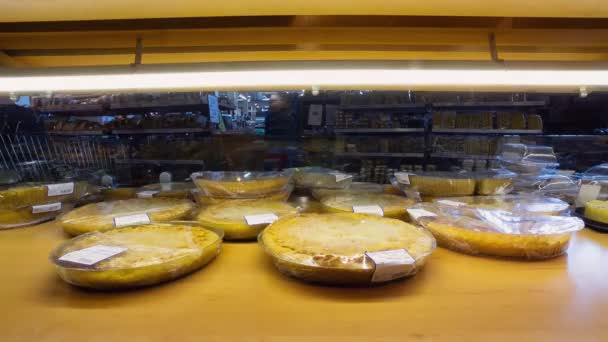 Vendedora pone deliciosos pasteles en exhibición en el supermercado — Vídeo de stock