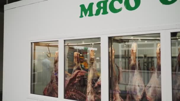 Hurtownia mięsa z zawieszonymi tuszami za oknem — Wideo stockowe