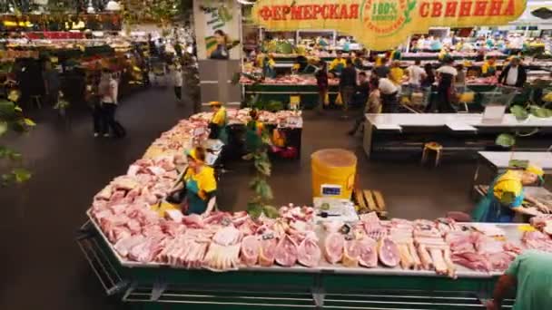 Vendeuses se tiennent près du comptoir avec de la viande de porc crue fraîche — Video