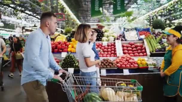 Familie mit kleinem Kind wählt Gemüse auf Bauernmarkt — Stockvideo