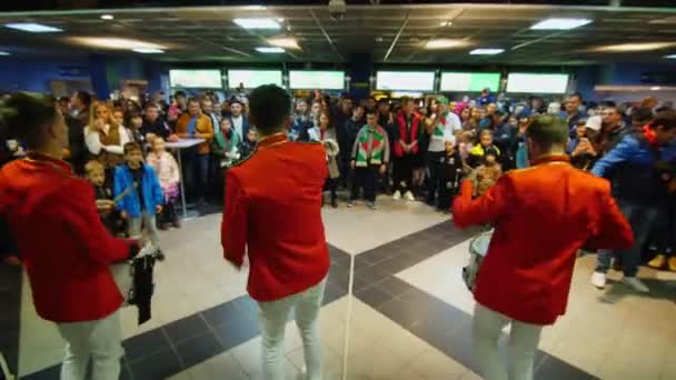 Banda de música en chaquetas rojas entretiene a la gente en la sala del estadio — Vídeos de Stock