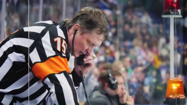 Stanco giudice di hockey in uniforme colloqui al telefono durante la partita — Video Stock