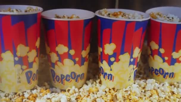 Tazze di carta colorate piene di deliziosi popcorn in mostra — Video Stock