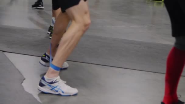 Atleta in scarpe da ginnastica fa esercizi sportivi con banda in palestra — Video Stock