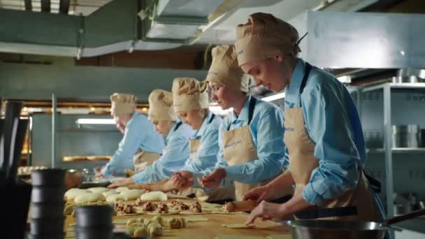 Mitarbeiterin backt mit Kollegen leckere Kuchen in Bäckerei — Stockvideo