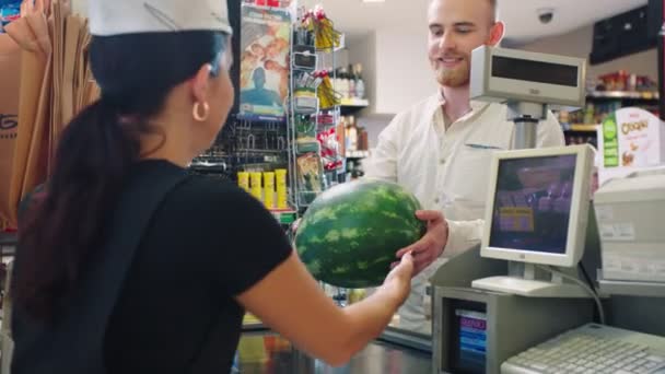 Férfi ad nagy görögdinnye pénztáros szupermarketben — Stock videók