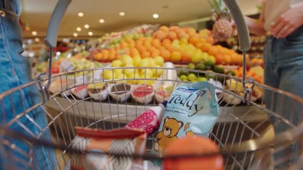 Nő dobja ananász kosárba termékek a piacon — Stock videók