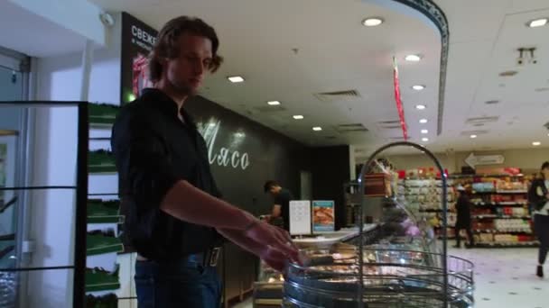 Handsome man comes into supermarket to buy fresh products — Stock Video