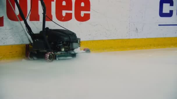 Man worker cleans ice arena walking with special machine — Stock Video