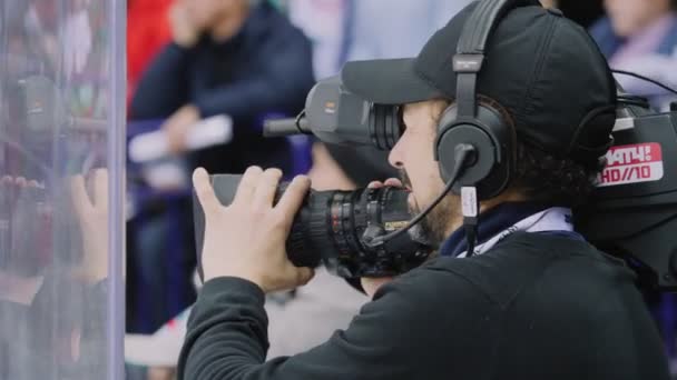 Κάμεραμαν με εξοπλισμό ταινίες παιχνίδι χόκεϊ στον πάγο παγοδρόμιο — Αρχείο Βίντεο
