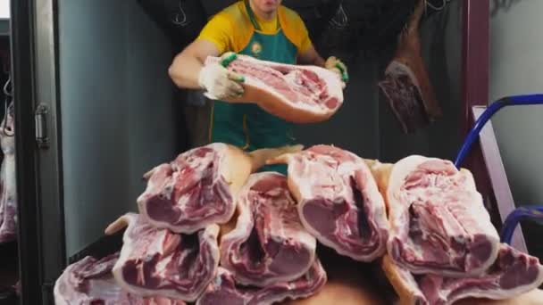 Angajatul pune bucăți de carcase de porc pe grămadă în camion — Videoclip de stoc