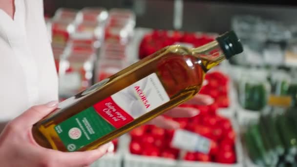 Леди смотрит на оливковое масло и дает человеку с корзиной — стоковое видео