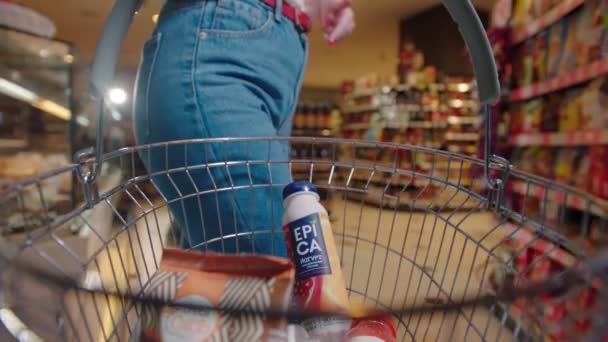 Женщина бросает кукурузные закуски в корзину в супермаркете — стоковое видео