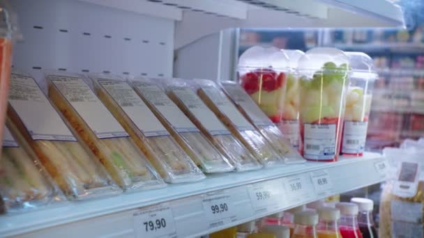 Hombre toma sabrosos sándwiches frescos de rack en el supermercado — Vídeo de stock