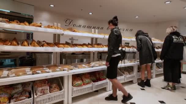 Люди ходят, чтобы взять свежие пироги и булочки в домашней пекарне — стоковое видео
