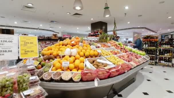 Клиенты берут фрукты из коробок на дисплее в супермаркете — стоковое видео