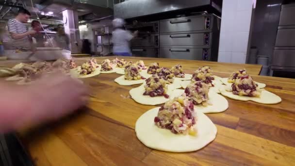 빵굽는 사람 이 식탁 위에서 소세지와 치즈와 함께 맛있는 파이를 만든다 — 비디오