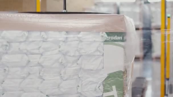 Máquina envolve pacotes de lã mineral com papel alumínio no armazém — Vídeo de Stock