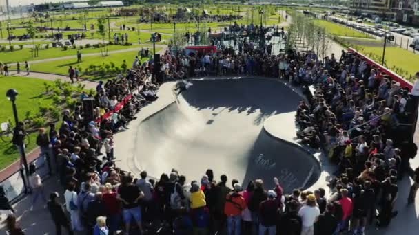 Espectadores assistir skater fazendo truques surpreendentes na piscina do parque — Vídeo de Stock