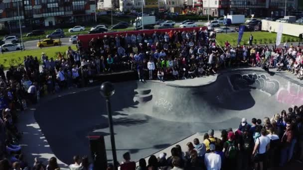Mann gjør triks på skateboard i basseng foran tilskuere – stockvideo