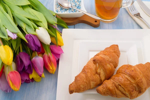Tulipany jasne, herbata z cytryną, wypieki na białym talerzu — Zdjęcie stockowe