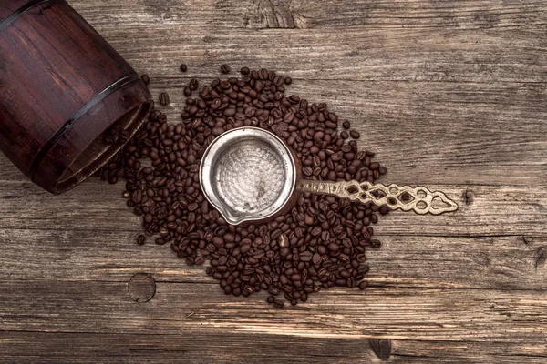 Turken med kaffebönor på ett gammalt träbord — Stockfoto