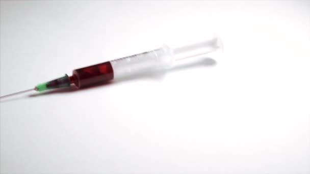 Syringe of red liquid falling and bouncing — Stock Video